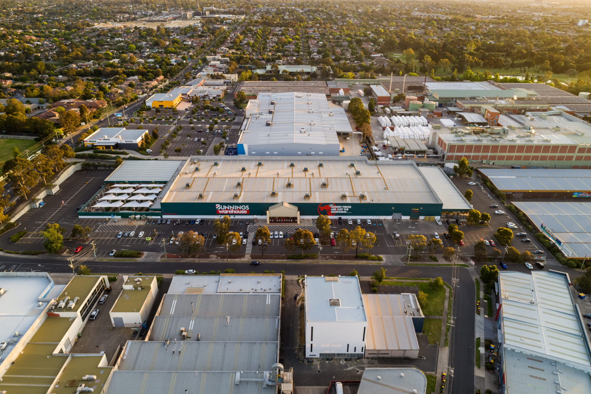 Golden hour aerial photograph of Bendigo Warehouse surrounded by suburban streets and industrial buildings, shot by drone