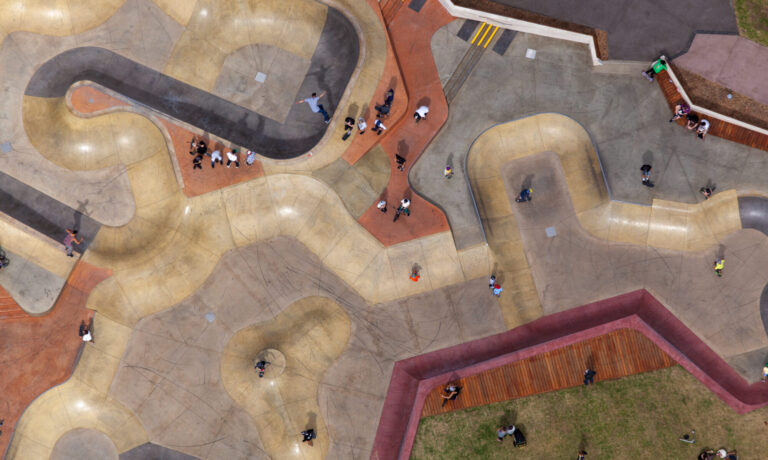 Aerial photography of St Kilda Skate Park Melbourne showing skaters and curved concrete bowls captured from a fixed-wing aircraft