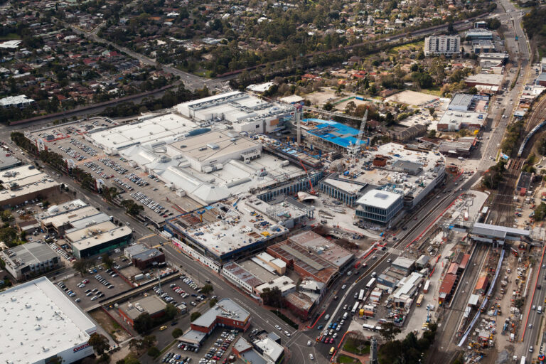 Aerial photography of Eastland construction progress in Melbourne showing large scale commercial development, cranes and surrounding infrastructure captured from a fixed wing aircraft