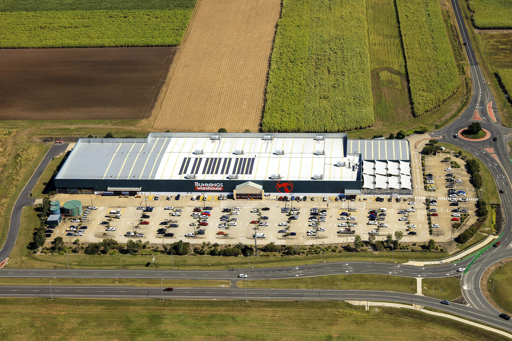 Aerial view of a Bunnings Warehouse store and car park bordered by agricultural fields