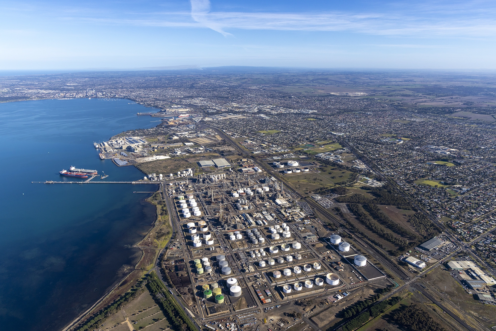 Daytime helicopter aerial photography of the Viva Energy refinery and fuel storage tanks in Geelong, Victoria.