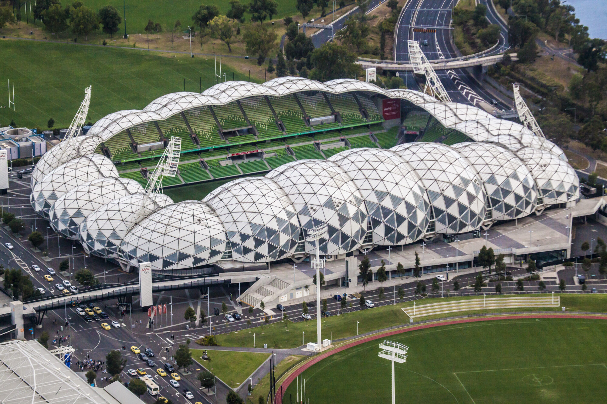 Aerial photograph of AAMI Park stadium in Melbourne showing the geodesic roof structure and surrounding precinct